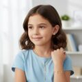 Delicate silver birds bracelet on a young girl with brown hair and a blue shirt.