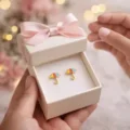 Delicate umbrella-shaped earrings in a white gift box with pink ribbon.