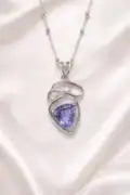 Sterling silver pendant with a purple tanzanite gemstone and small accent stones.
