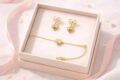 Gold heart earrings and bracelet set in a jewelry box.