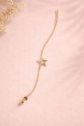Gold-plated star pendant necklace on pink background.