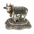 Silver cow and calf figurine with intricate designs and a small bell.