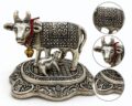 Silver cow and calf figurine with intricate patterns and red thread.
