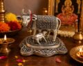Decorative silver cow idol for Hindu worship and prosperity rituals.