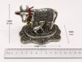 Silver Hindu cow figurine with calf on ornate base, detailed craftsmanship.