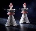 Elegant silver diya lamps with pink accents and crystal flames.