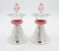 Pair of silver oil lamps with pink accents and intricate designs.