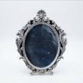 Vintage silver ornate picture frame with dark background.