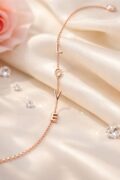 Delicate rose gold silver necklace with love pendant on satin fabric.