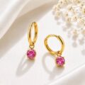 Gold hoop earrings with pink gemstone charms on a white background.