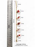 Gold chain bracelet with small Santa and gift charms, next to a ruler for scale.