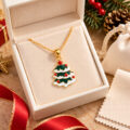 Gold-plated Christmas tree pendant with red accents in jewelry box.