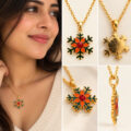 Gold snowflake pendant necklace with red center on model.