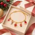 Gold charm bracelet with festive charms including snowman Santa and reindeer in a gift box.