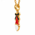 Side profile of gold Santa hat pendant with black enamel bow.